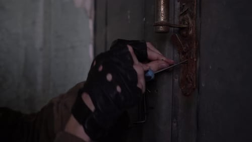 A Burglar Tries to Open a Door with an Old Lock with a Master Key Closeup Hands