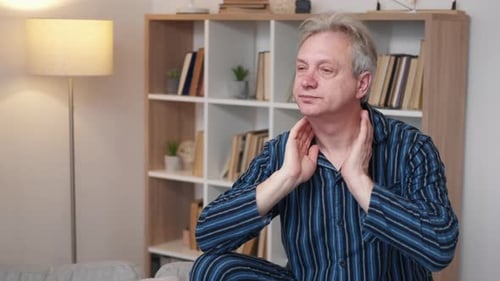 Adult Man Massaging Stiff Neck at Home