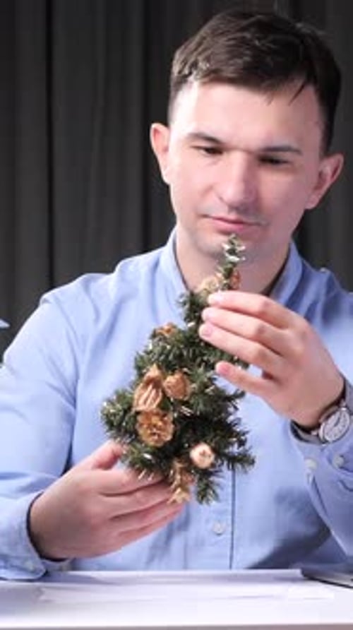 Vertical Video Office Worker Decorating Desk with Miniature Christmas Tree Work