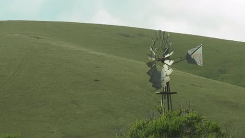 Windmill in front of Pastoral California Hills Close Up 4K