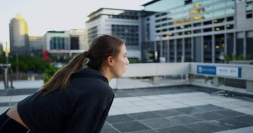4k video footage of an attractive young woman checking the time while out jogging in the city