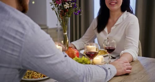 Romantic Dinner at Home During the Quarantine of a Man and a Woman Sitting at a Table with Candles