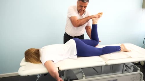 Woman Receives Leg Manipulation from Therapist