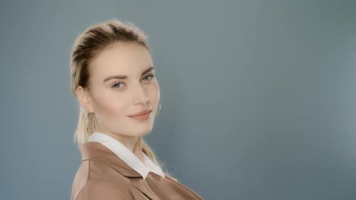Confident businesswoman poses in studio for fashion portrait on grey background