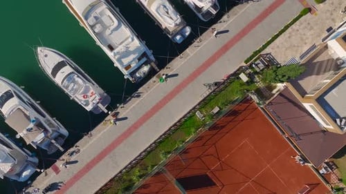 Aerial Video Aerial View of a Harbor With Tennis Courts and White Yachts on Bright Blue Water