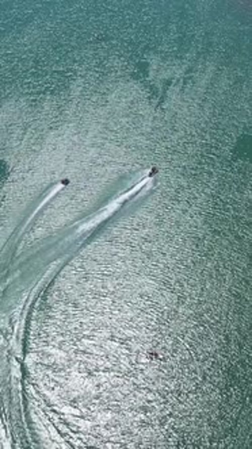 Tubería remolcada en un lago en un día soleado de verano, vista aérea, vídeo vertical