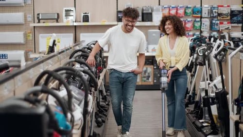 Customers choosing vacuum cleaner in electronics store in slow motion