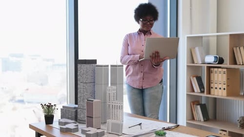 Architect Working with Laptop and Building Models