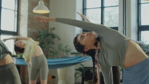 Young Adults Stretch Together During Yoga Class