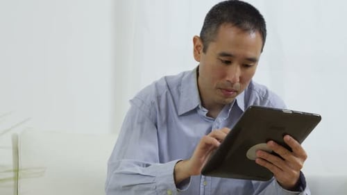 Man using tablet device in bright indoor setting