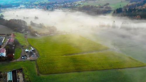 flight over valley green valley with morning mist and a small rural village