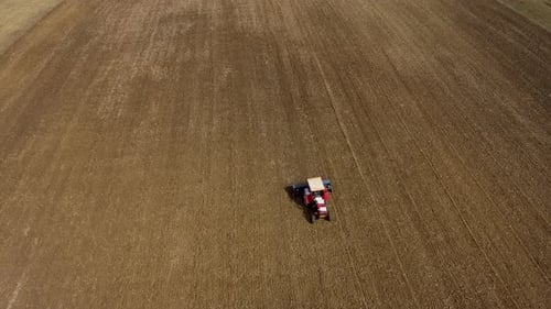 Tractor Seeding-Sowing Crops at Agricultural Field. Soil Loosening Aerial Slow Motion