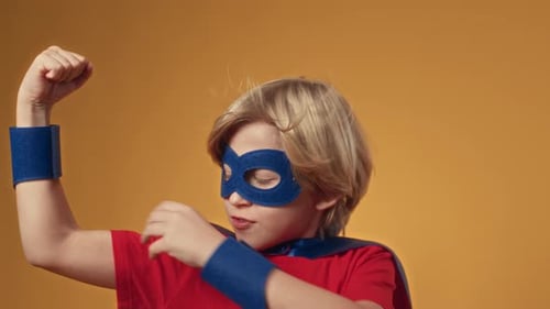 Blond Boy Flexing in Superhero Costume