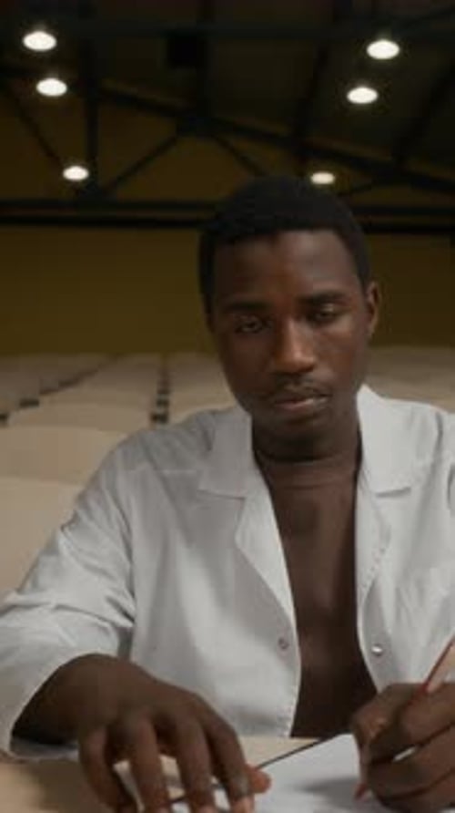 Portrait of Black Male Medical Student Studying at Desk in Lecture Room
