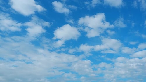 White Clouds Drifting Across Blue Sky Time-Lapse