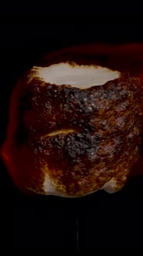 Roasted Marshmallow over Fire on Black Background