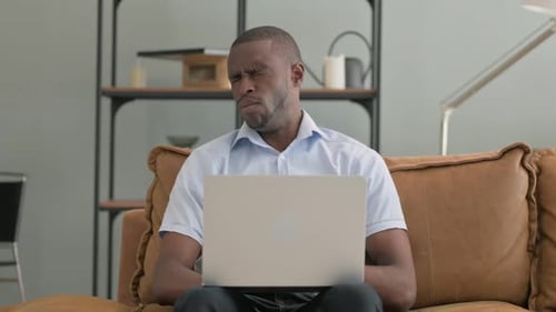 Man Working on Laptop Yawning