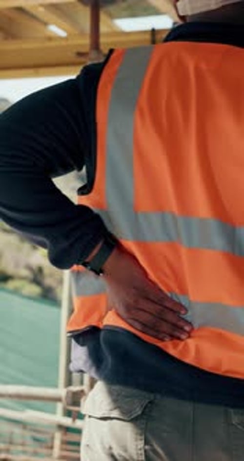 Construction, hurt or man with back pain on site for heavy lifting, work accident or sore spine