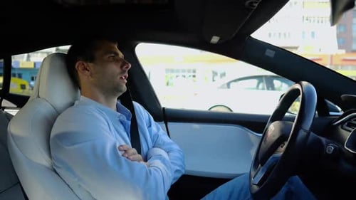 Male Businessperson Experience to Ride an Autonomous Self Driving Electric Car at Urban Road