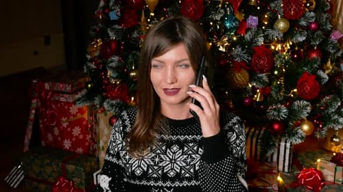 Woman Talking on Phone in Front of Christmas Tree