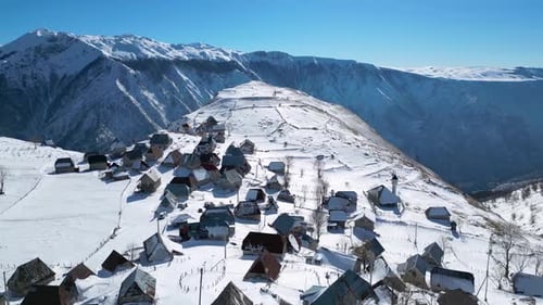 Aerial drone view of mountain village during winter. Snow white landscape and mountaineer lifestyle.
