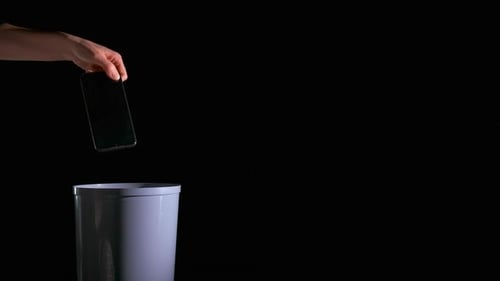 Hand Throwing Smartphone into a Trashcan