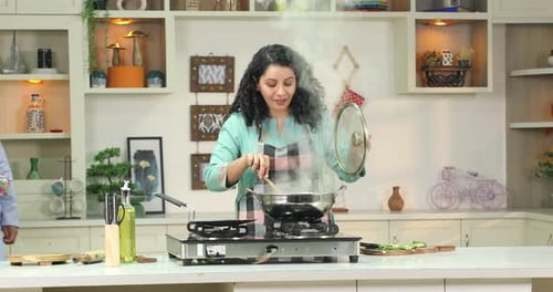 Woman Receives Gift While Cooking in Kitchen