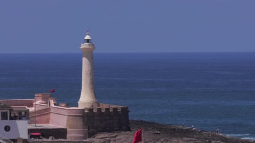 Morocco's scenic coastline with a panoramic view of a historic lighthouse by the ocean in Casablanca