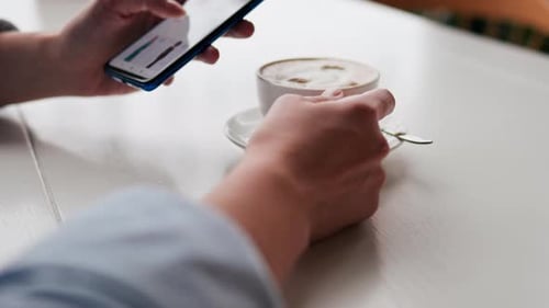Woman using Phone While Having Cappuccino