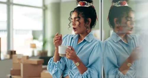 Woman Holding Mug Next to Glass Partition