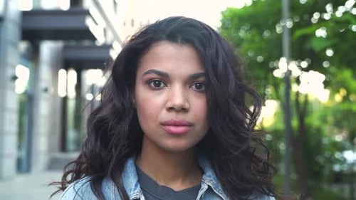 Beautiful Young Woman Looking at Camera on City Street, Portrait