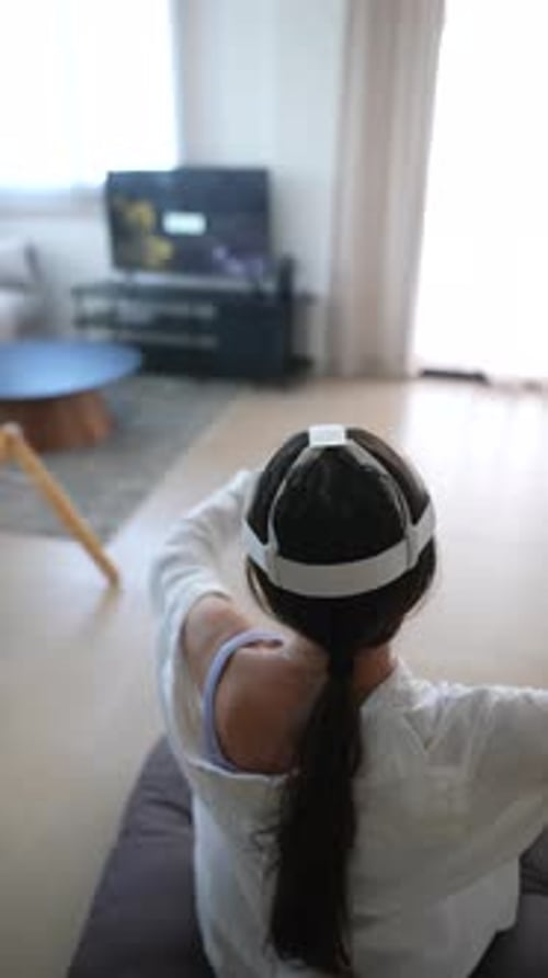 Woman Gaming with Virtual Reality Headset Indoors