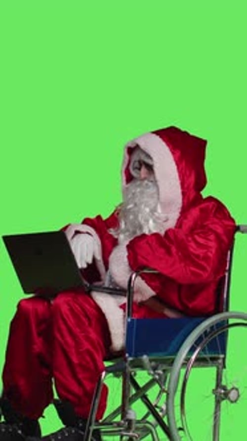 Vertical Video Side View of Saint Nick with Disability Using Laptop