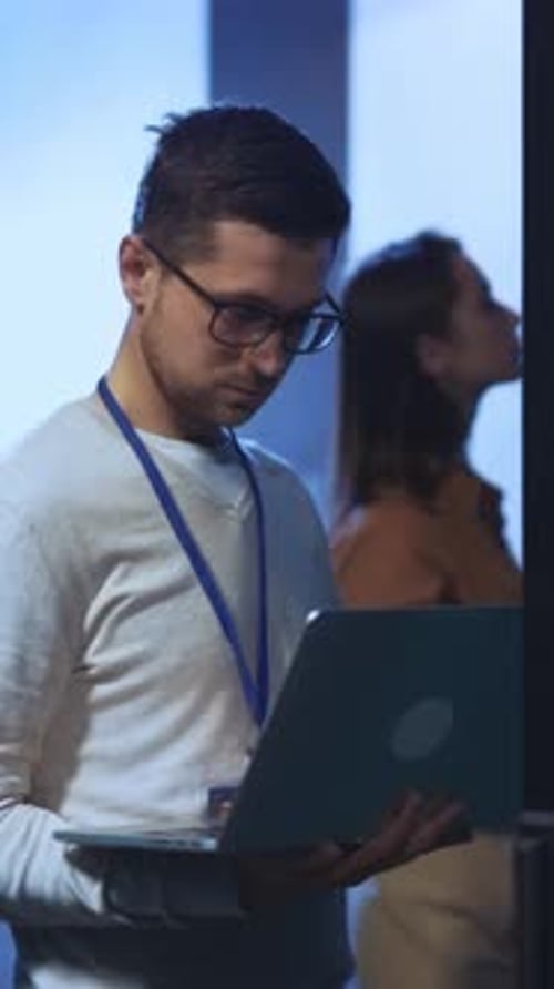 Young Adult Working on Laptop in Server Room