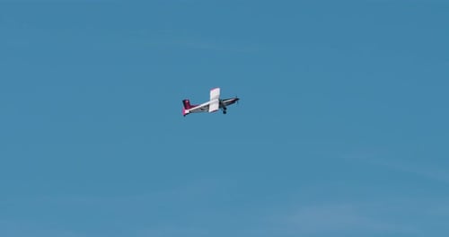 Airplane Flies Through Blue Sky on Sunny Day