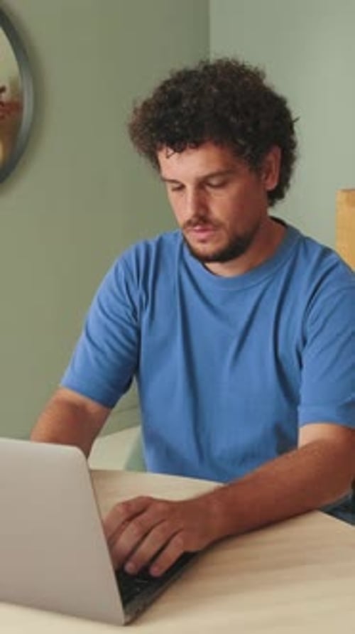 Man Works on Laptop in Home Office