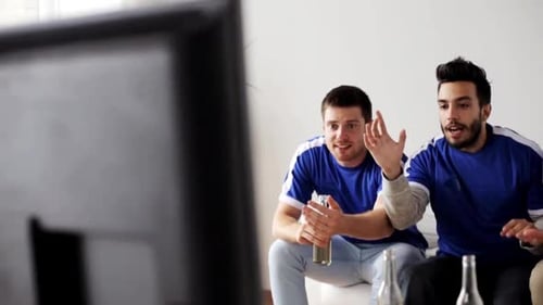 Enthusiastic men watching sport game on tv indoors