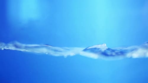 Water Surface Slow Motion Abstract Background. Bubbles rise to the surface. Fresh water waves with s