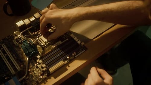 Mann hebt den Sockeldeckel, entfernt die CPU von der Hauptplatine und inspiziert sie am Schreibtisch