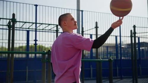 Man Spinning Basketball on Finger Outdoors