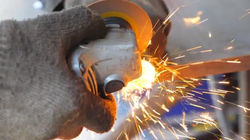 Detail View on Metal Processing with Circular Saw Hands of Mechanic Holding Instrument and Grinding