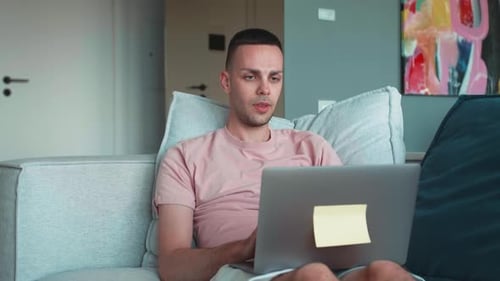 Hombre caucásico autónomo cansado que usa una computadora portátil con dolor de cabeza, problemas de tensión y migraña