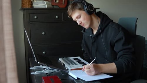 Young Man Focused on Creating Music at Home Studio