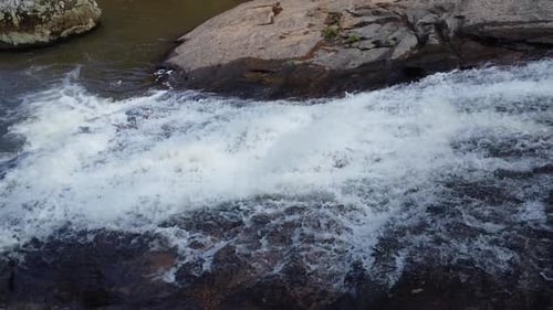 Tropical River Cascading Over Rocks in Natural Landscape