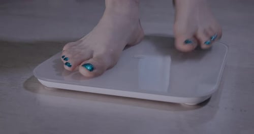 Women's Legs Standing On Electronic Scales