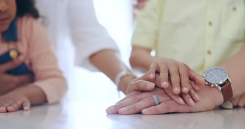 Family Stacking Hands Together Indoors Close Up