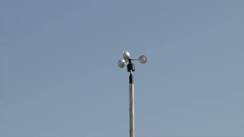 Anemometer measuring wind speed against blue sky