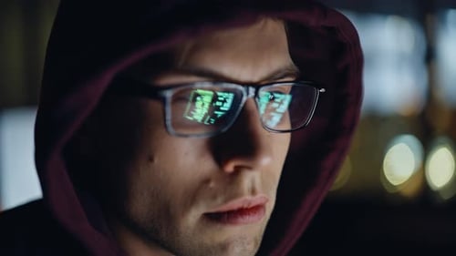Focused Man With Code Reflected in Glasses