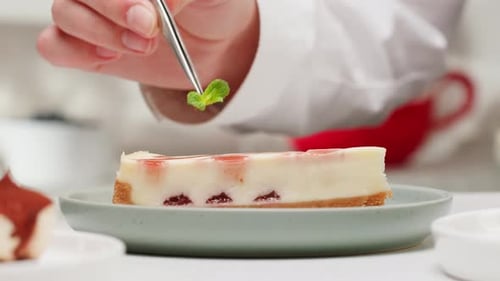 Chef Decorating Cheesecake with Mint in Close Up