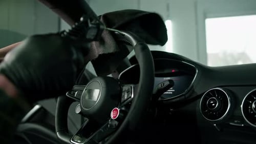 Worker cleans steering wheel professional brush and clout of microfiber Professional car wash
